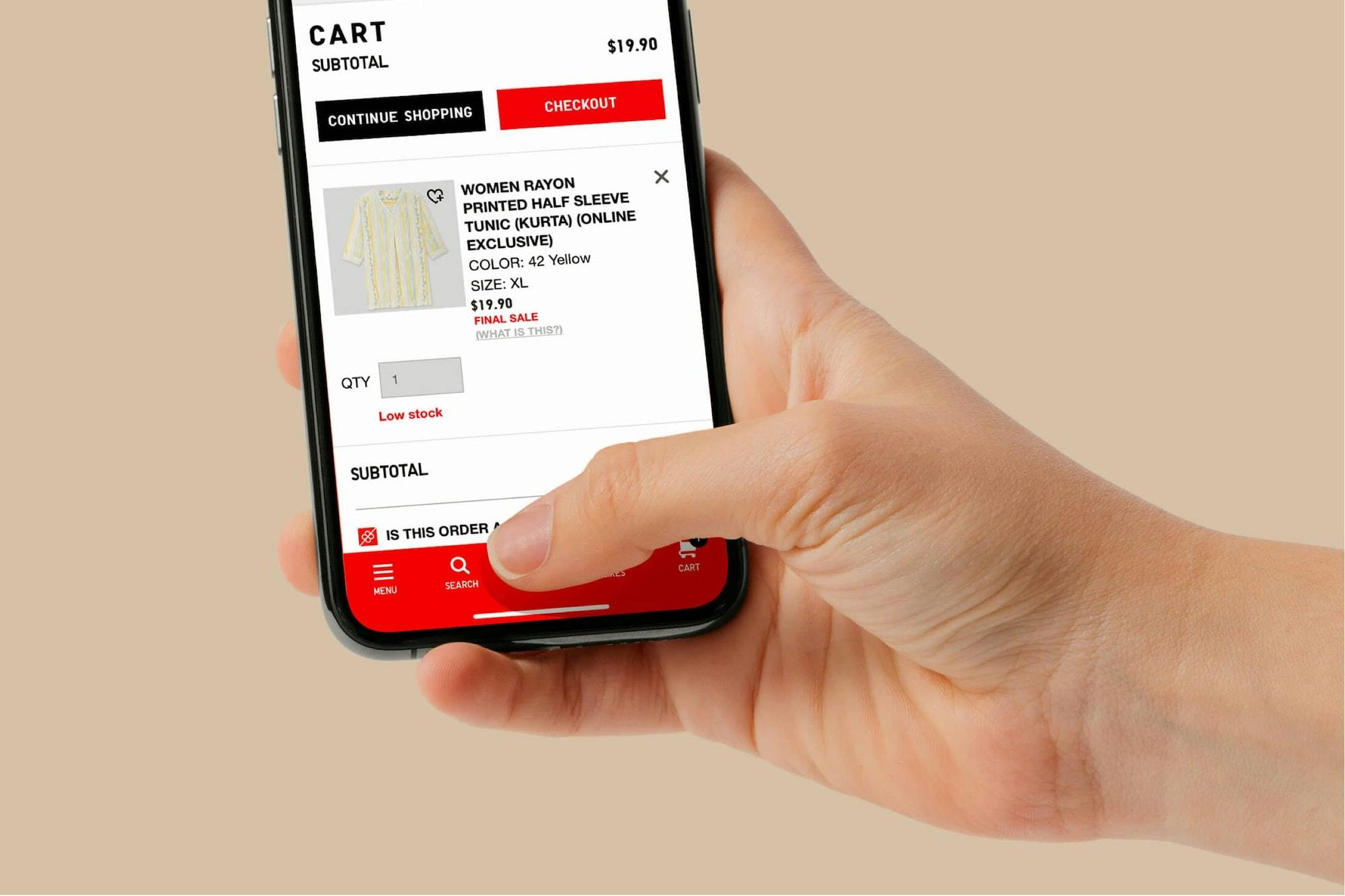 hand holding a smartphone with UNIQLO.com displayed